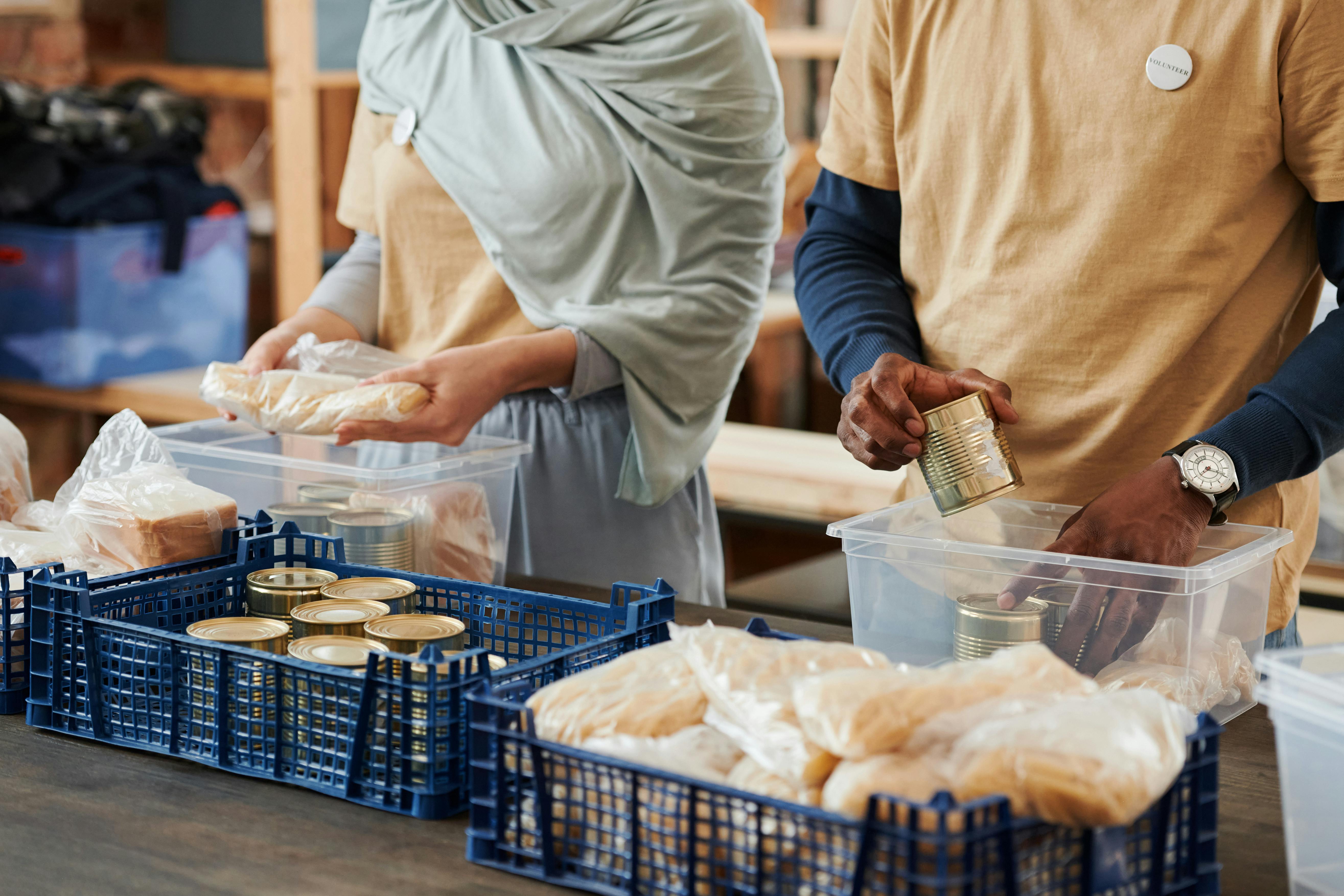 Volunteers packing food donations into crates and containers at a community food drive